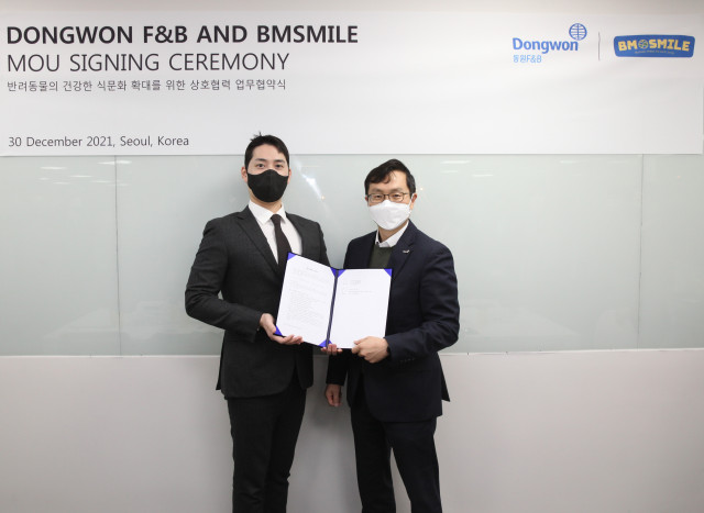 왼쪽부터 모성현 비엠스마일 한국 대표와 이상진 동원F&amp;B 전략사업부장이 업무 협약을 맺고 기념촬영을 하고 있다