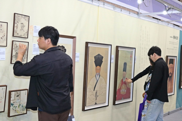 관람객들이 ‘2023 세계국가유산 산업전’에 전시한 포스아트 한국화 작품들을 살펴보고 있다