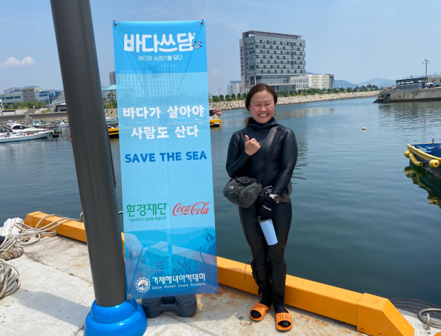 거제해녀아카데미 소속 활동가 해녀 신영 씨가 수중 정화활동을 통해 깨끗해진 바다를 배경으로 활짝 웃고 있다(사진=환경재단)