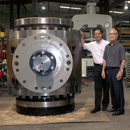 맷 모가스(왼쪽)와 루이스 모가스(오른쪽)가 거대한 모가스 밸브 옆에서 포즈를 취하고 있다(사진: 비즈니스와이어)