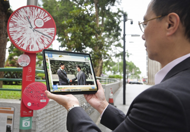 The Secretary for Culture, Sports and Tourism, Mr Kevin Yeung, used the new movie function of the City in Time mobile app to revisit Hong Kong classic movie clip. (Photo credit: The Tourism Commission)
